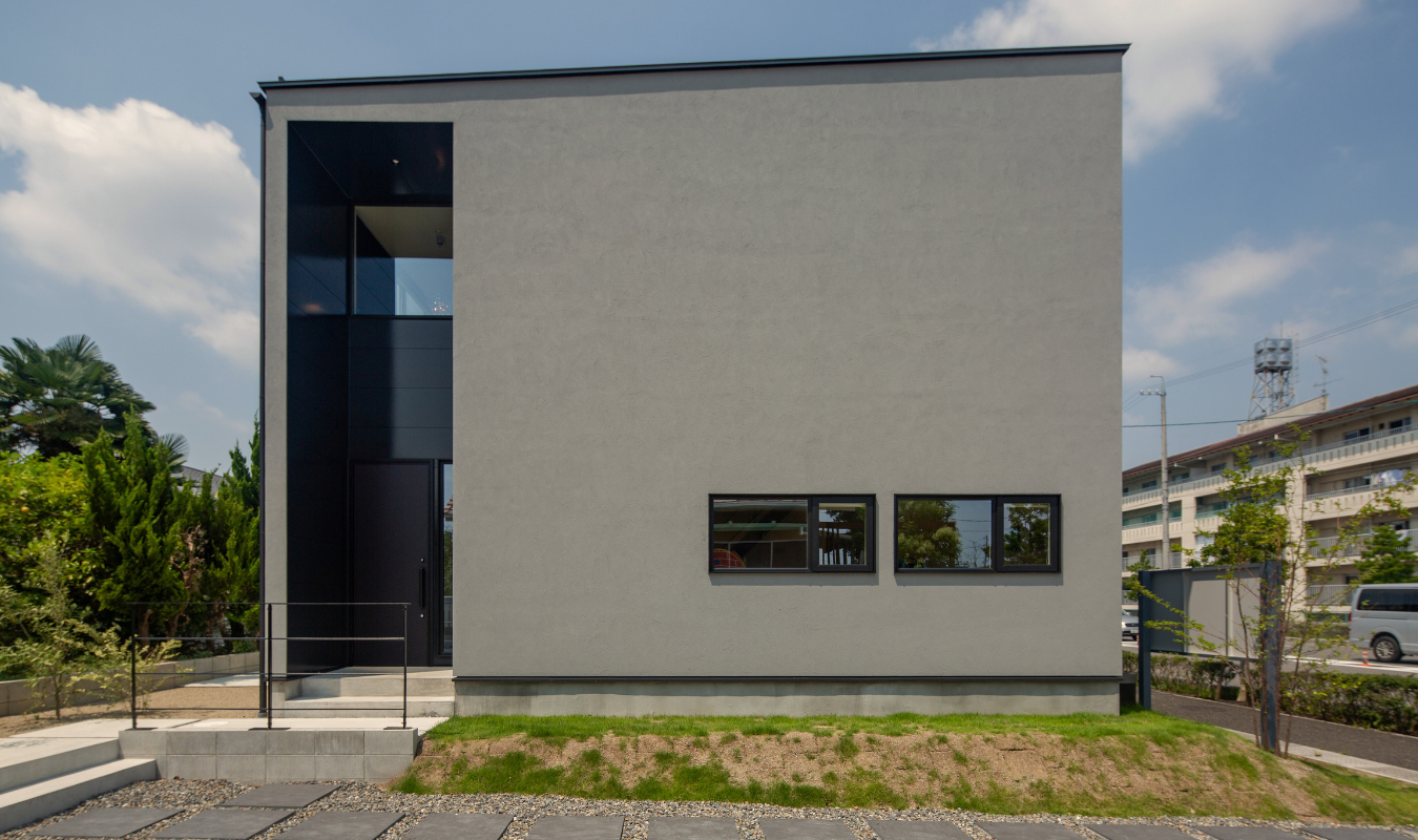 2019年大垣市坂下モデルハウスの外観。シンプルなグレーの箱型デザインと縦に抜けるエントランスが特徴の住まい