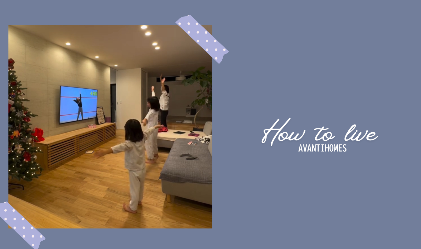 リビングで親子が一緒に体を動かし、音楽に合わせて楽しく踊る家族の暮らしの様子