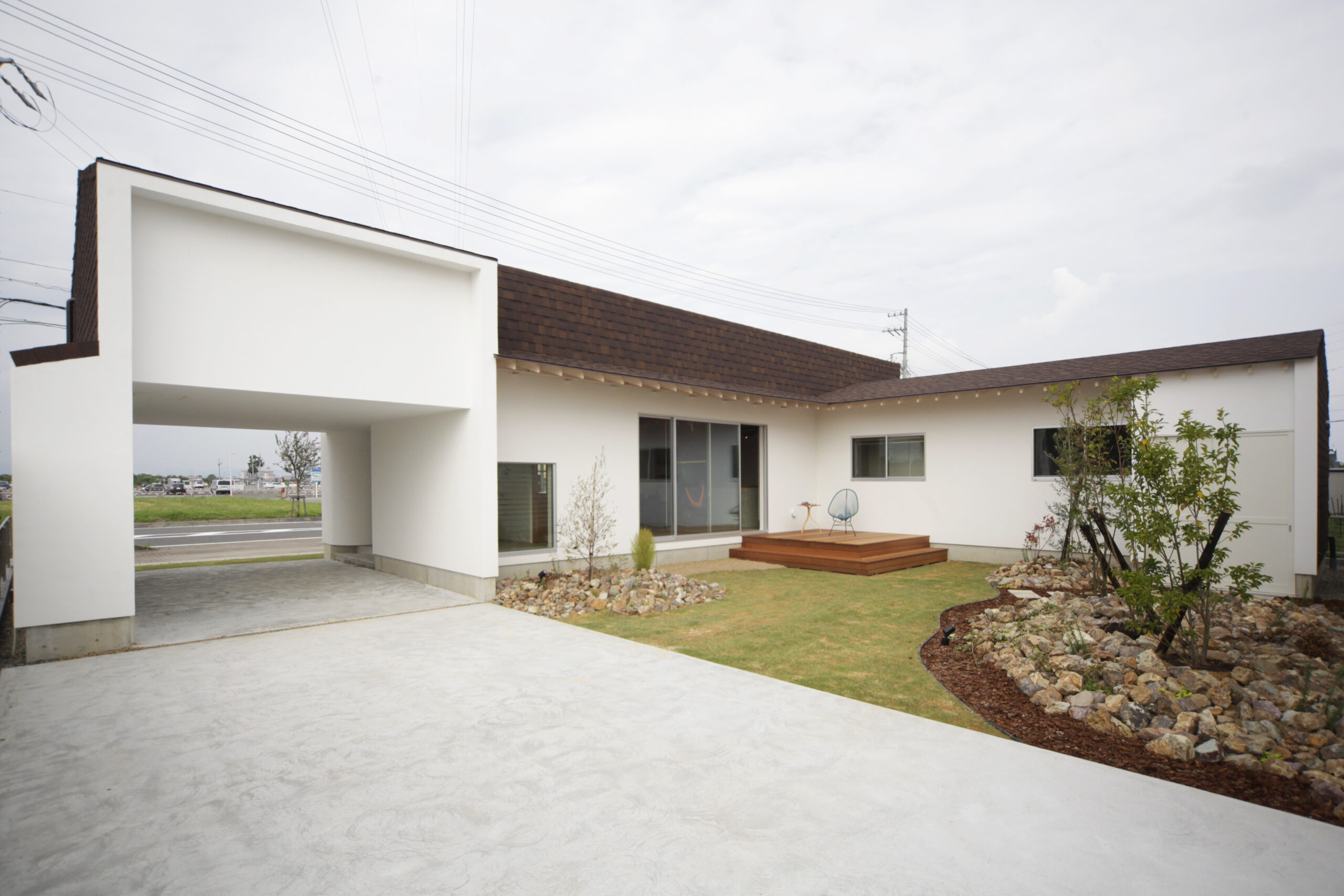 インナーガレージと中庭を備え、自然素材を取り入れたモデルハウスの施工例写真。