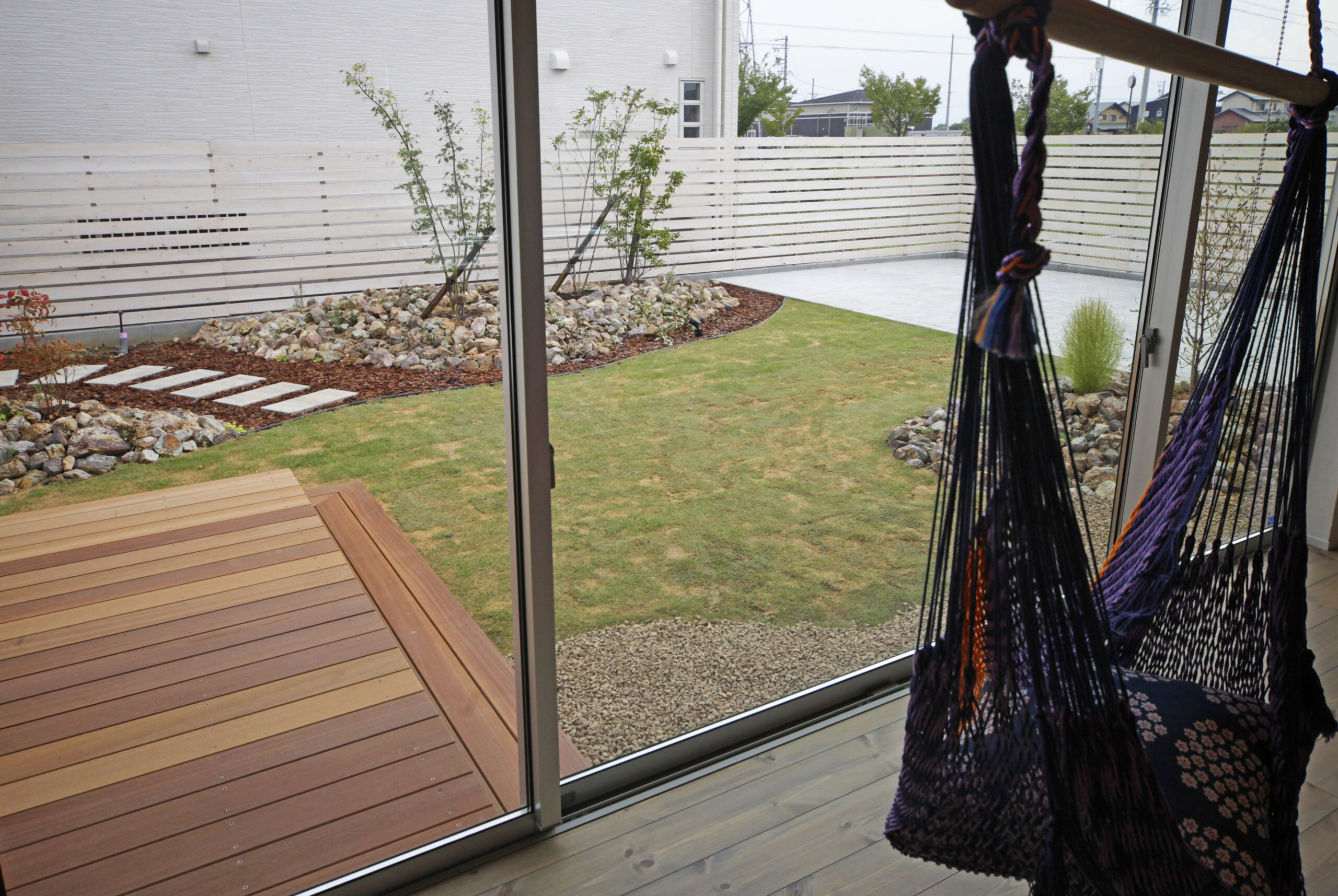 インナーガレージと中庭を備え、自然素材を取り入れたモデルハウスの施工例写真。