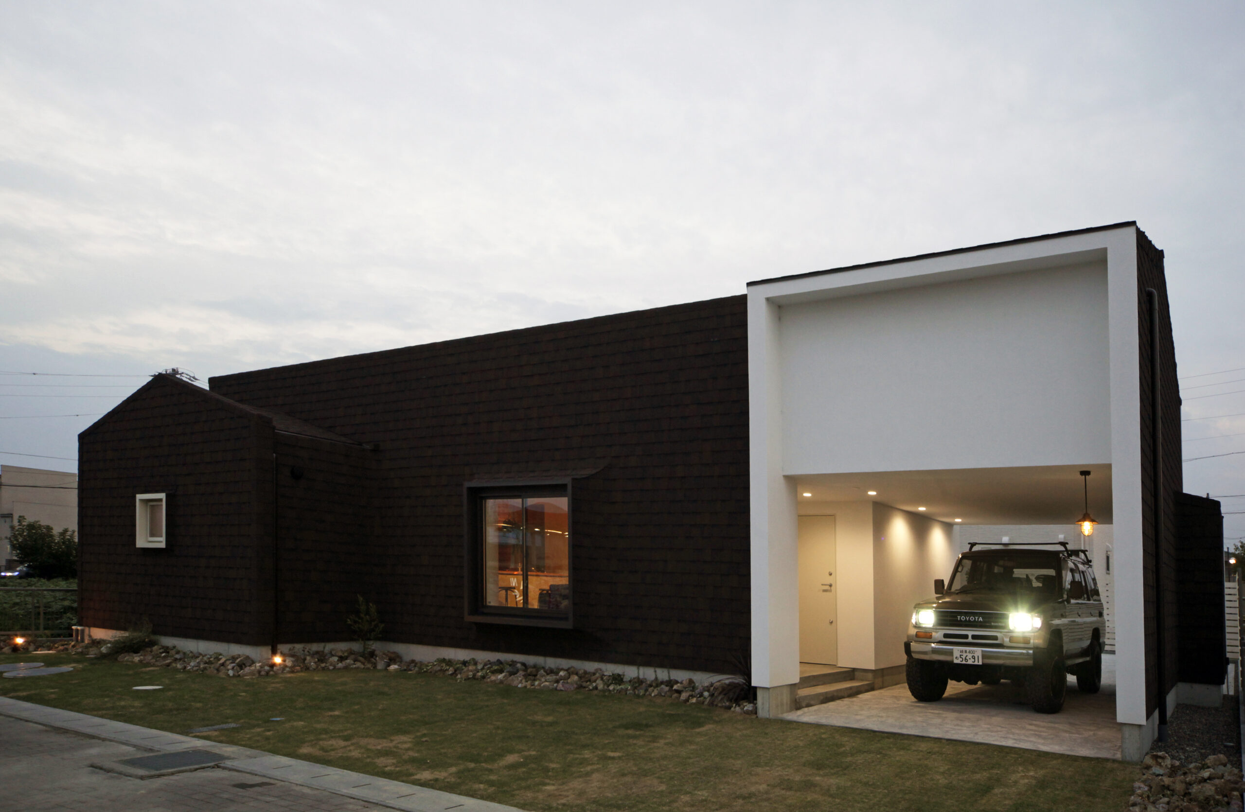 インナーガレージと中庭を備え、自然素材を取り入れたモデルハウスの施工例写真。