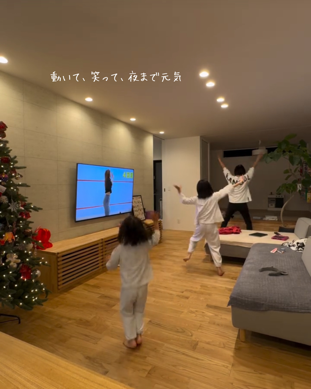 明るいリビングで子どもたちと親が一緒に踊り、笑顔が広がるあたたかな家族の時間